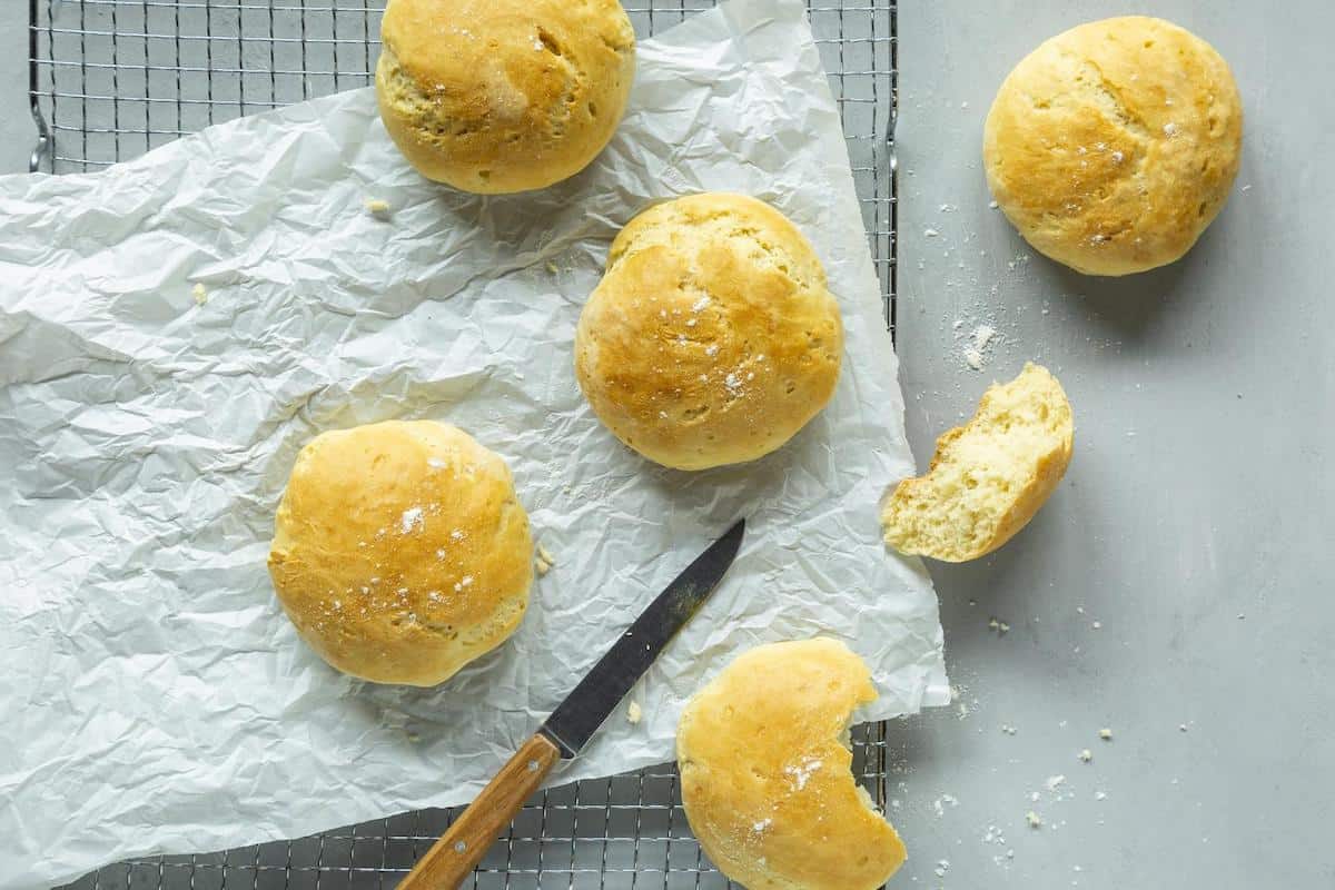 MIlchbrötchen auf Butterbrotpapier daneben ein Messer