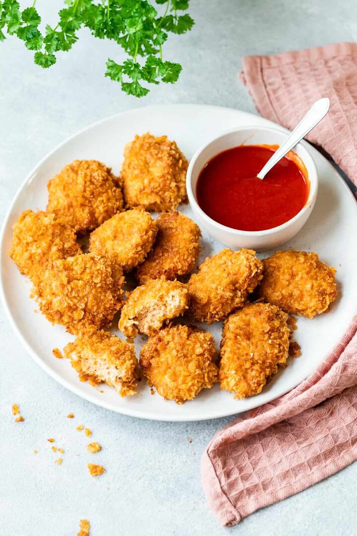 Chicken Nuggets auf einem weißen Teller mit einem Schälchen Ketchup - Foto: Kathrin Knoll