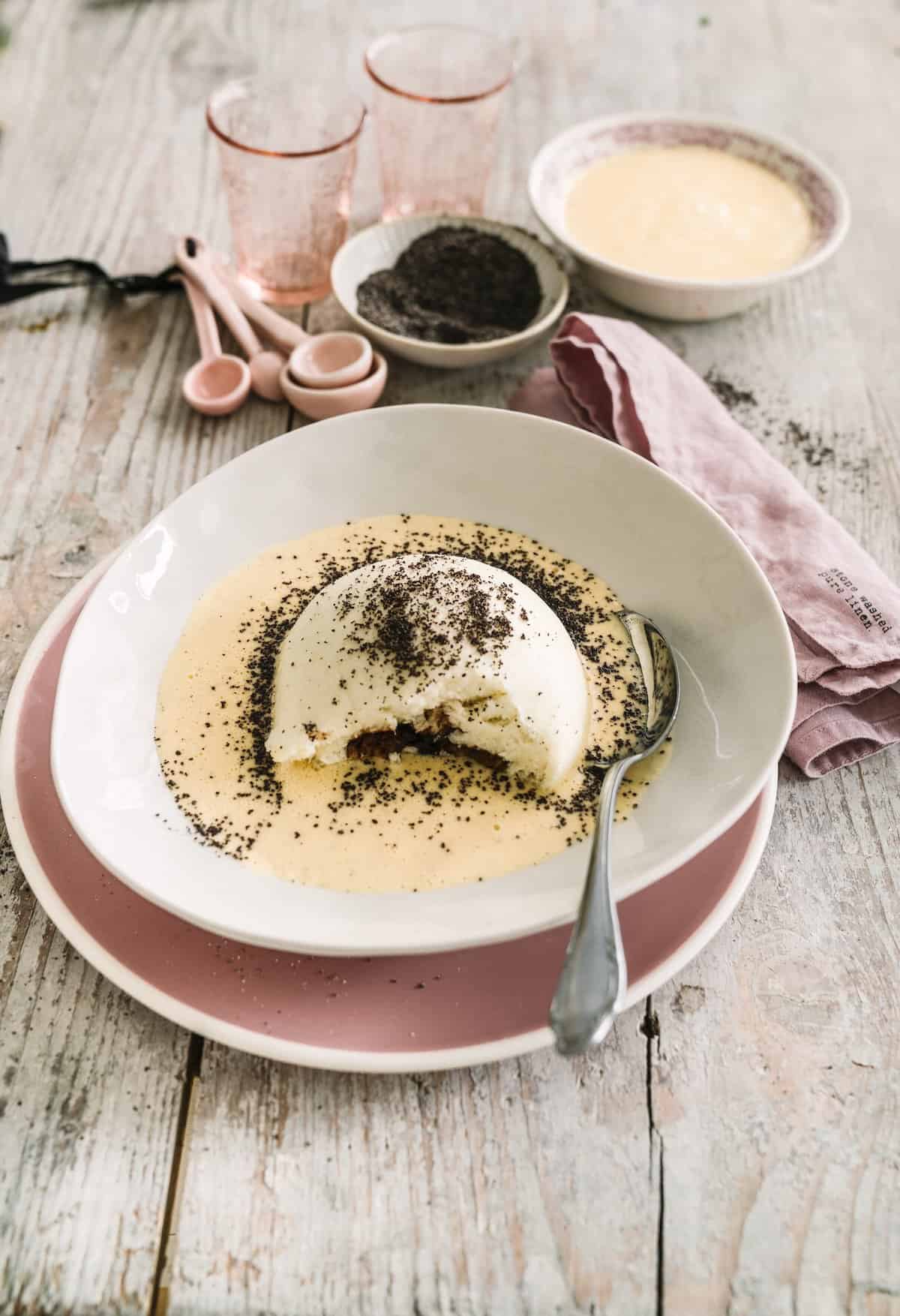 Germknödel mit Mohn und Vanillesoße auf einem hellen Teller – Foto: Tina Bumann