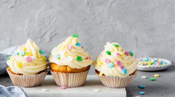 Drei Cupcakes mit Frosting und bunten Streuseln