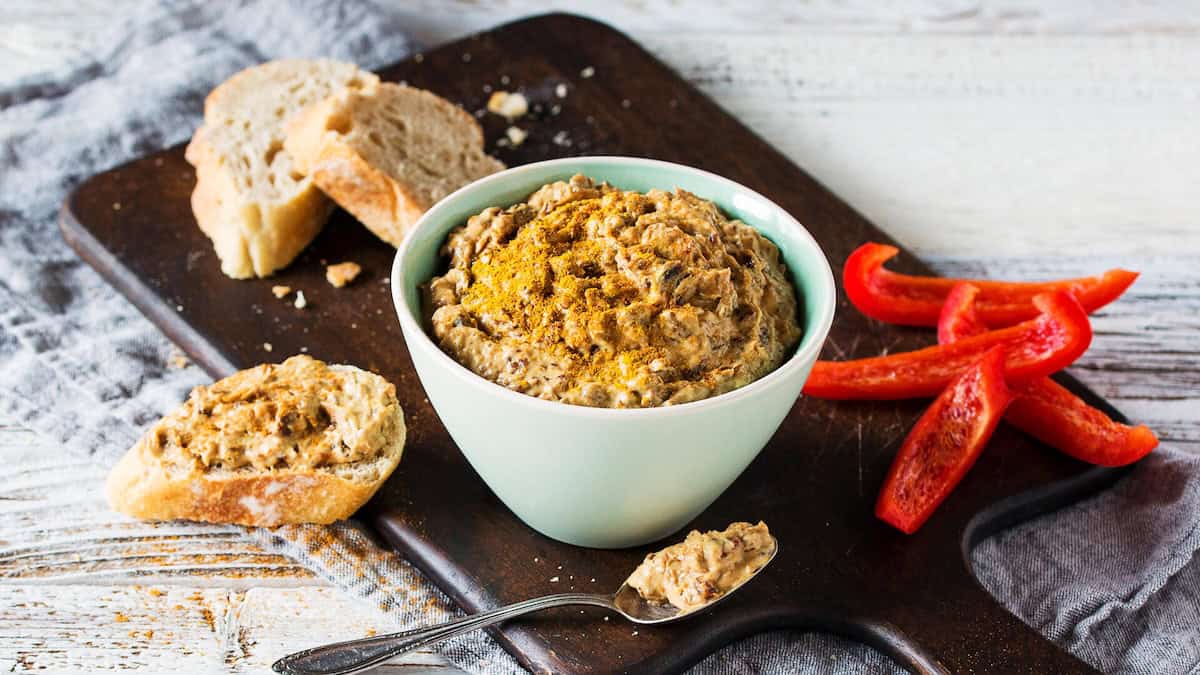 Pflaumen-Curry-Dip in einer grünen Schale, daneben Brot und Paprika – Foto: Anna Gieseler