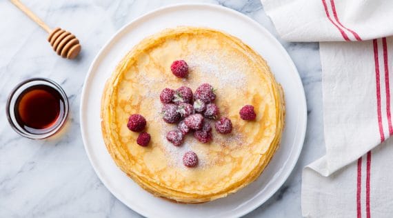 Pfannkuchen von oben fotografiert mit Himbeeren und Puderzucker