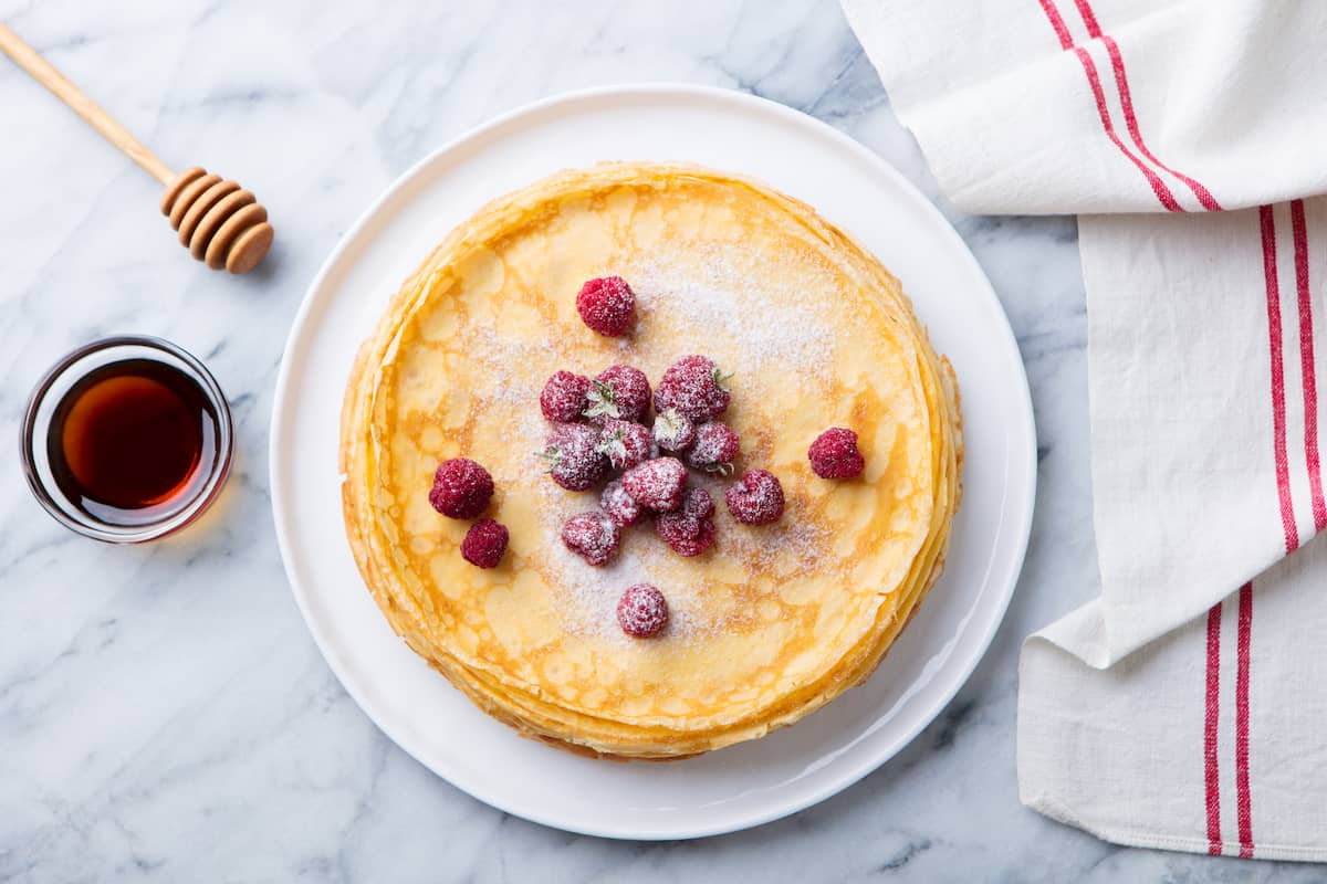 Pfannkuchen von oben fotografiert mit Himbeeren und Puderzucker