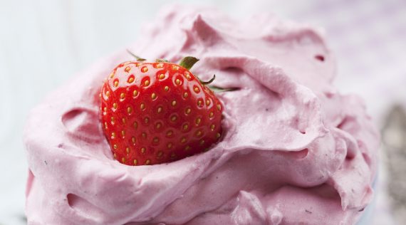 Cremiges Yogurette-Eis mit einer Erdbeere darauf