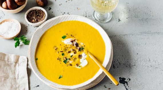 Ein weißer Teller mit orangefarbener Maronensuppe, von oben fotografiert – Foto: Désirée Peikert