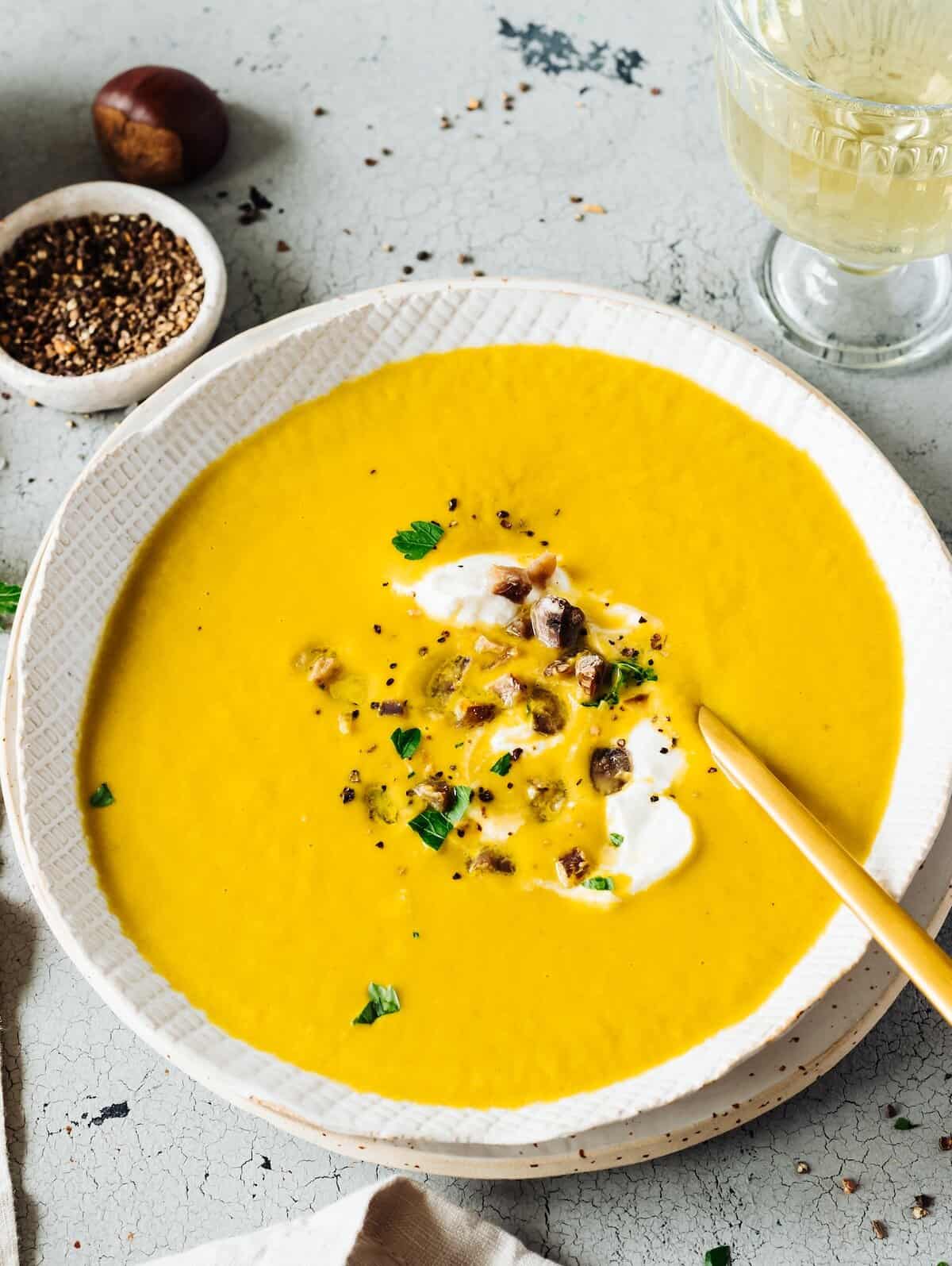 Ein weißer Teller mit orangefarbener Maronensuppe, von oben fotografiert – Foto: Désirée Peikert