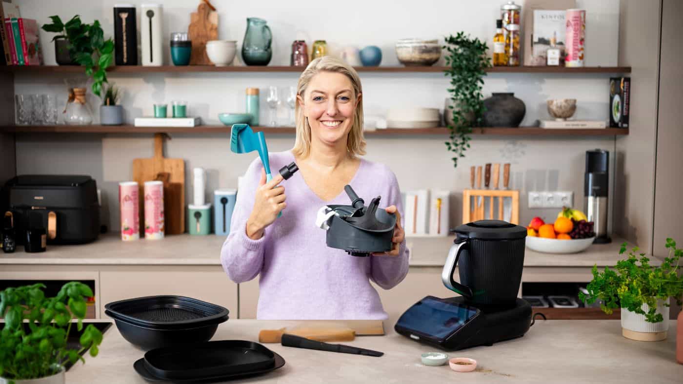 Eine blonde Frau mit einigem Zubehör, neben dem Thermomix® in einer Küche – Foto: Anna Gieseler