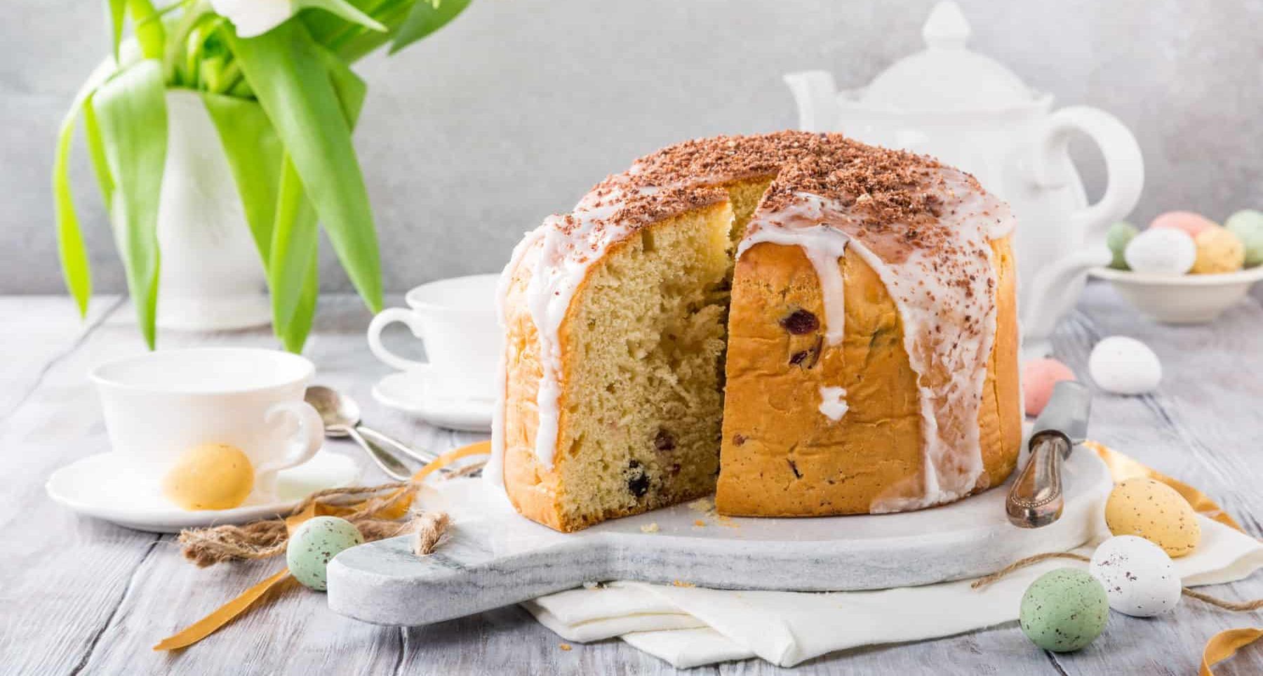 ein angeschnittenes Osterbrot mit Zuckerguss auf einer hellen Platte – Foto: gettyimages / Merinka