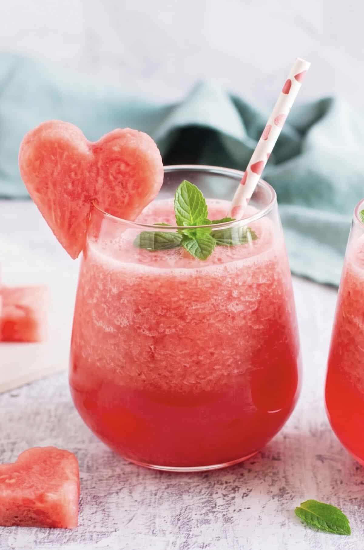 Zwei Gläser mit einem roten Getränk, garniert mit einem Stück Wassermelone