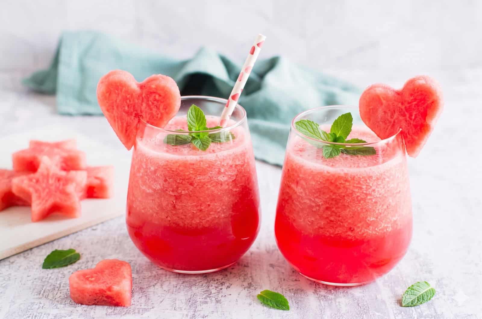 Zwei Gläser mit einem roten Getränk, garniert mit einem Stück Wassermelone