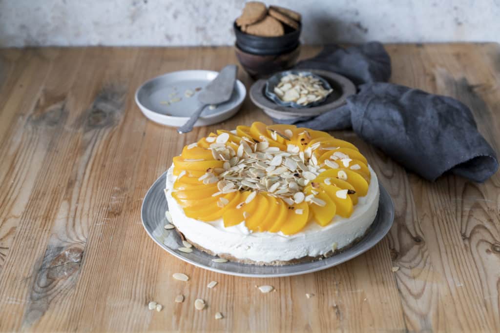 Pfirsichtorte mit Buttermilch aus der Springform auf Holzuntergrund