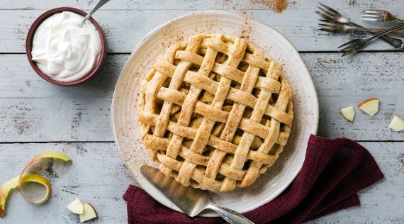 Apple Pie auf einem weißen Teller von oben fotografiert, danaben ein Schälchen mit Sahne