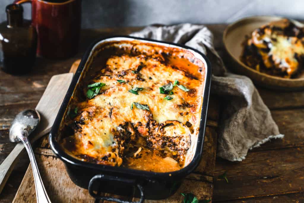 Schwarze Auflaufform mit angeschnittenem Linsen-Moussaka