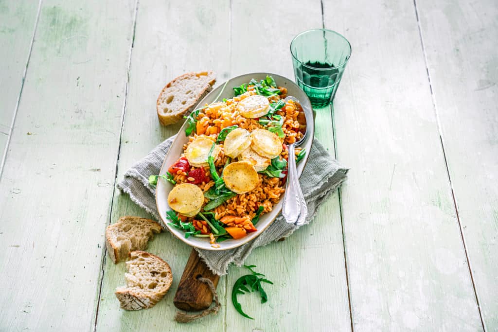 Weißer ovaler Teller mit Linsensalat mit Ziegenkäsetalern