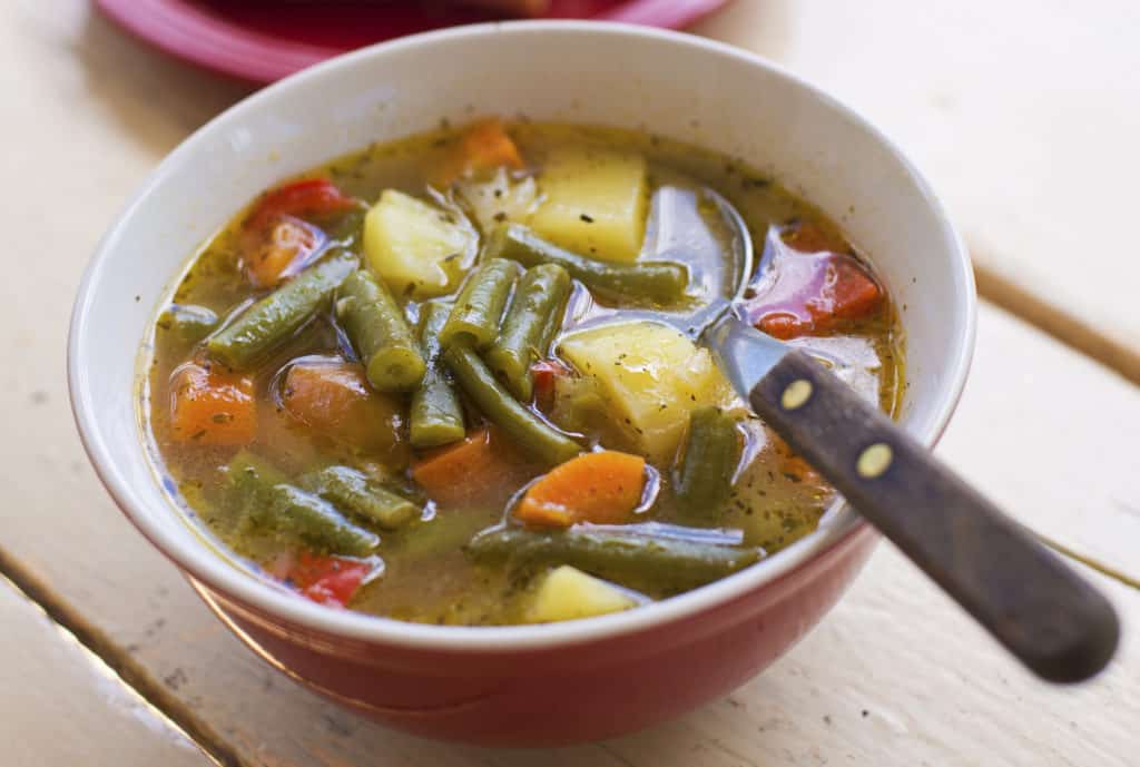 Bohnensuppe mit Kartoffeln und Möhren in einer roten Schüssel