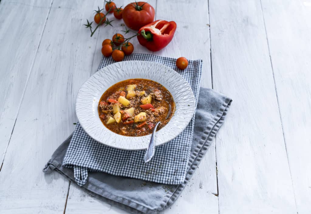 Bauerntopf mit Kartoffeln und Hackfleisch auf einem weißen Teller