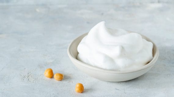 Veganer Eischnee in einer Schüssel auf grauem Untergrund