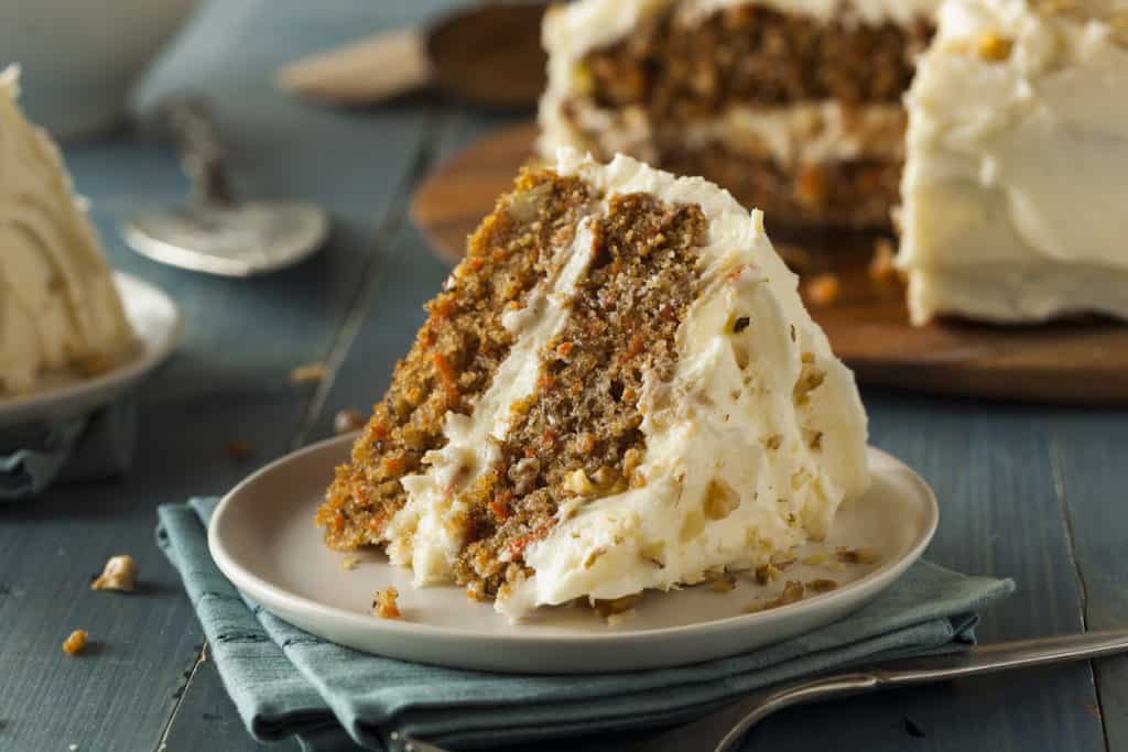 Ein Stück Carrot Cake mit Frosting auf einem grauen Teller – Foto: gettyimages / bhofack2