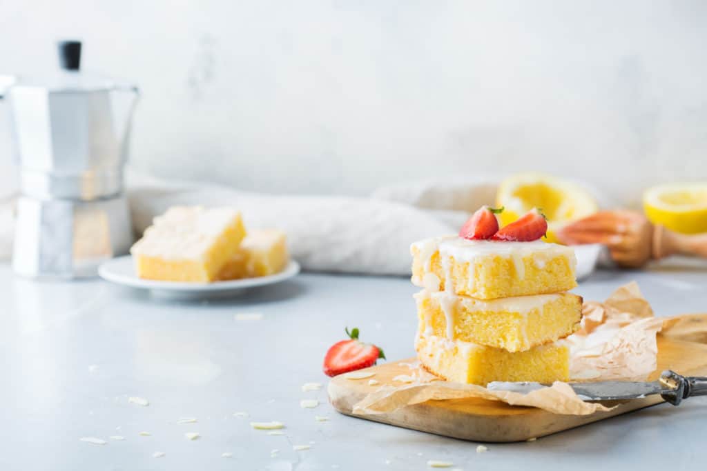 Drei Stück Zitronen-Blechkuchen mit Zuckerguss gestapelt
