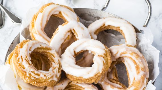 Feine Spritzkuchen mit Zuckerguss auf einem Teller