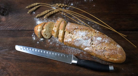 Zwiebelbrot in Baguetteform auf einem braunen Tisch, angeschnitten