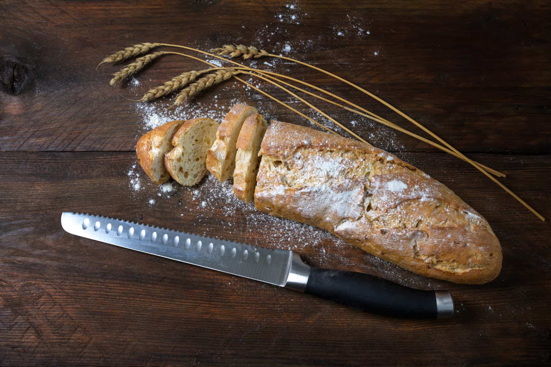 Zwiebelbrot in Baguetteform auf einem braunen Tisch, angeschnitten