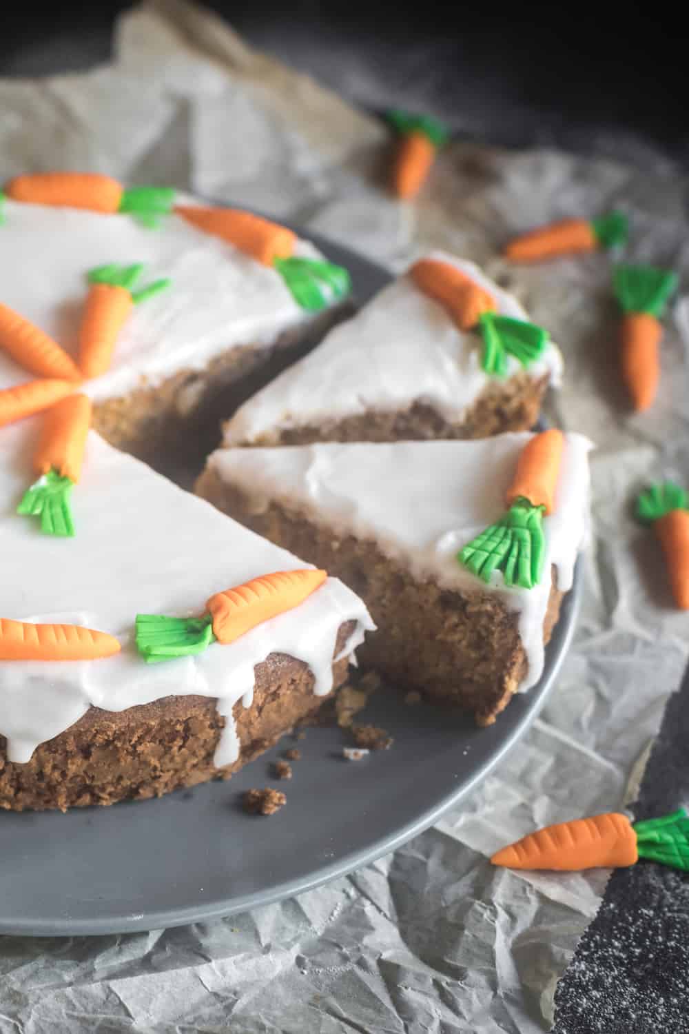 Zucchini-Karotten-Kuchen mit Zuckerguss und -Karotten dekoriert, angeschnitten