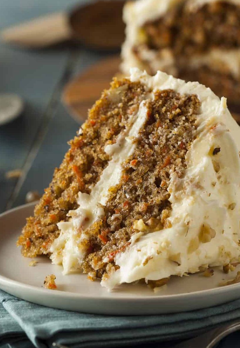 Ein Stück Carrot Cake mit Frosting auf deinem hellgrauen Teller