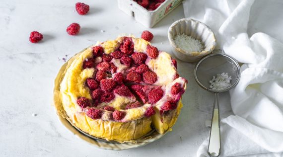 Käsekuchen mit Himbeeren auf einem weißen Teller