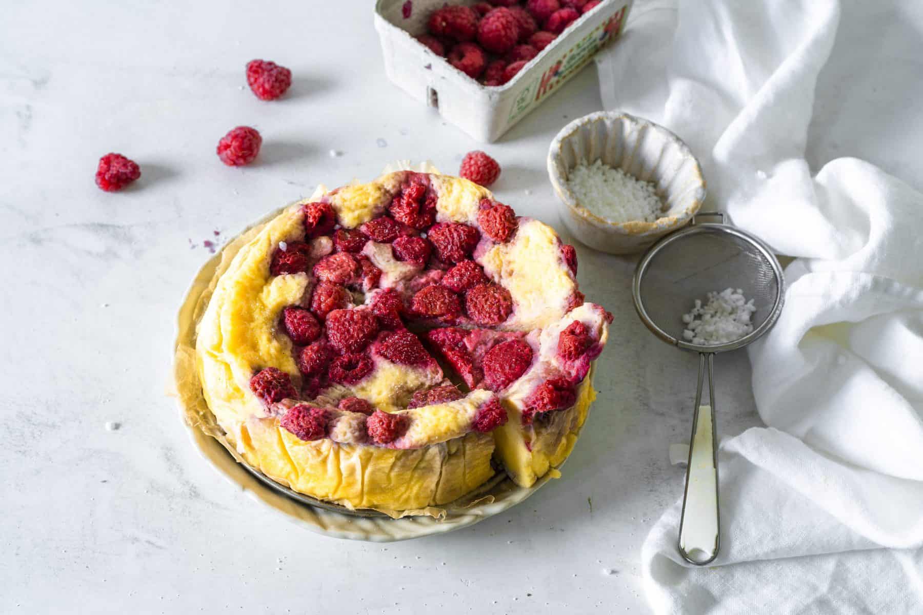 Käsekuchen mit Himbeeren auf einem weißen Teller