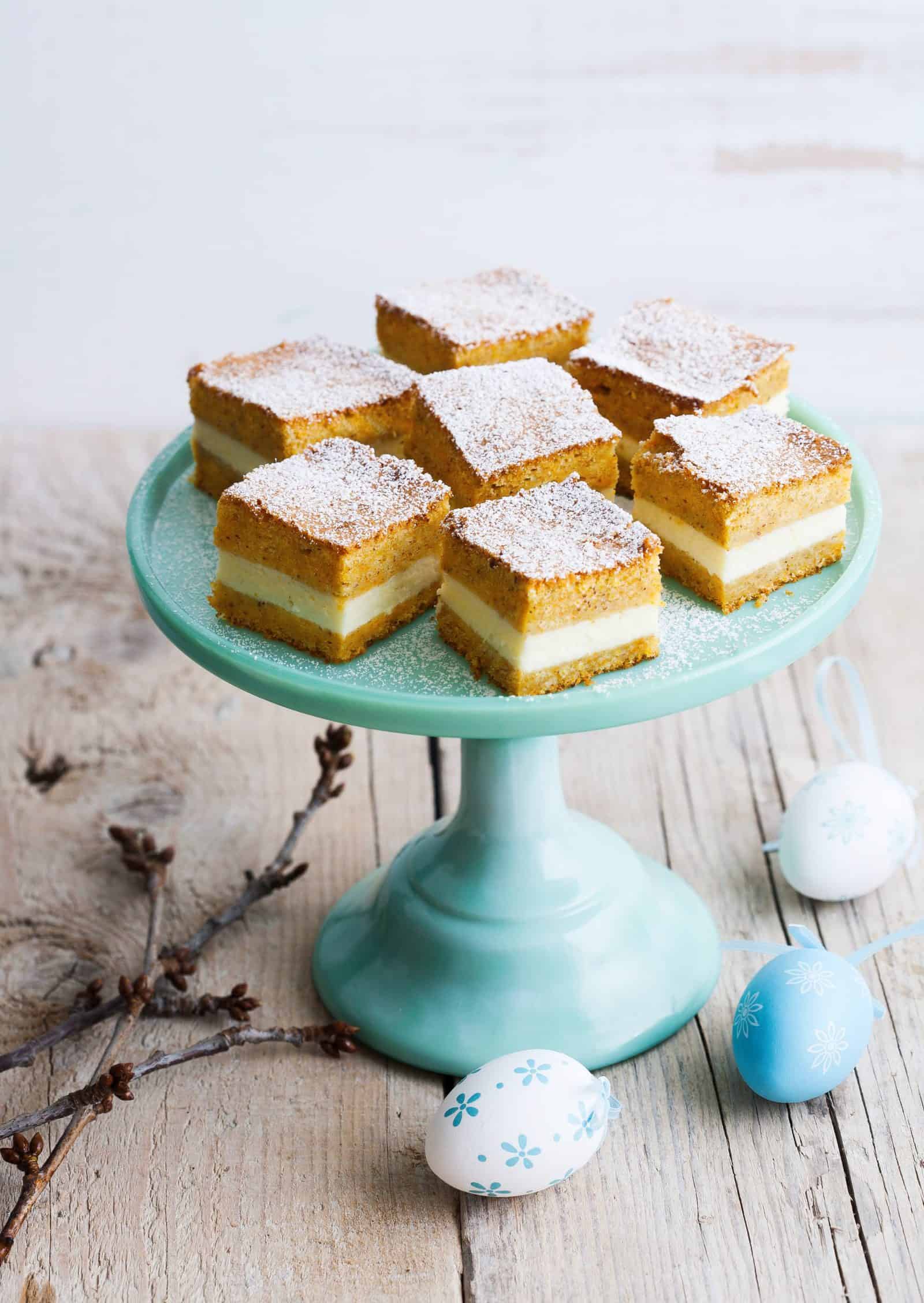 Kuchenwürfel mit Creme auf einem hellblauen Tortenteller