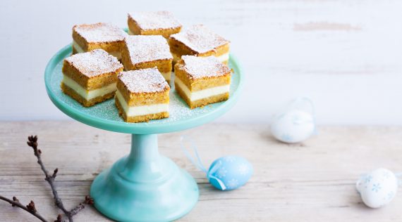 Kuchenwürfel mit Creme auf einem hellblauen Tortenteller