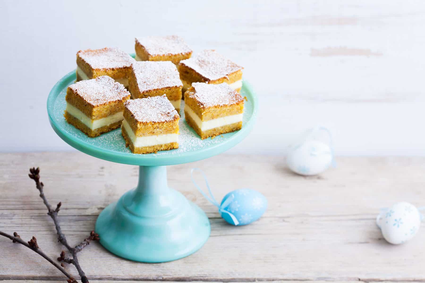 Kuchenwürfel mit Creme auf einem hellblauen Tortenteller