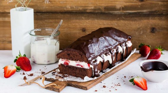 Schokoladenkuchen in Kastenform mit einer Sahne-Erdbeerfüllung, angeschnitten