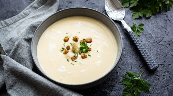 Spargelsuppe in einer grauen Schale mit Croûtons und Petersilie garniert