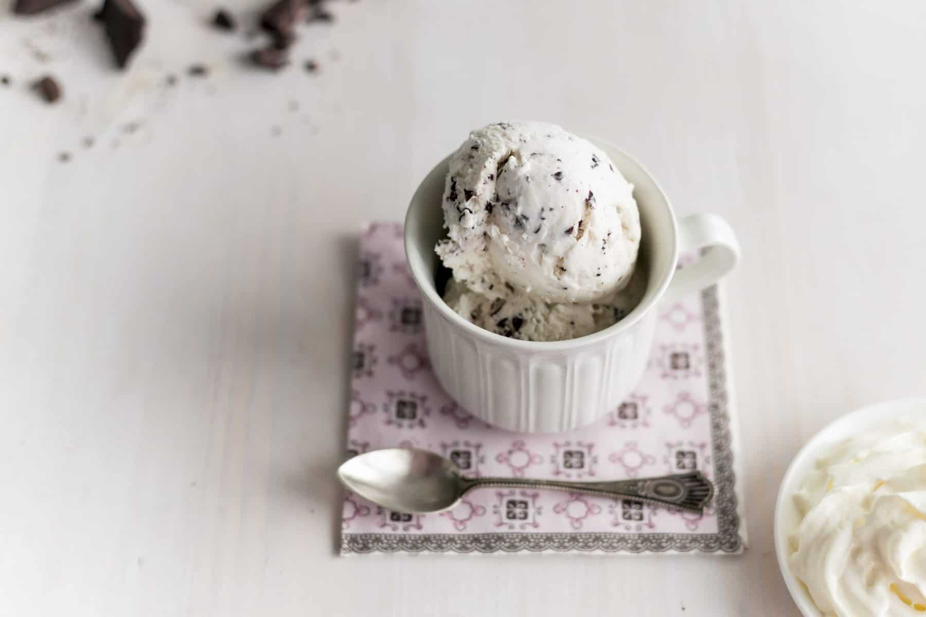 Eine Kugel Stracciatella-Eis in einem weißen Schälchen