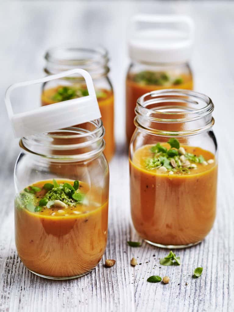 Tomatensuppe in Gläsern mit Pesto und Pinienkernen