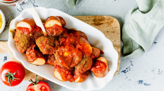 Currywurst mit Soße in einer weißen Schale