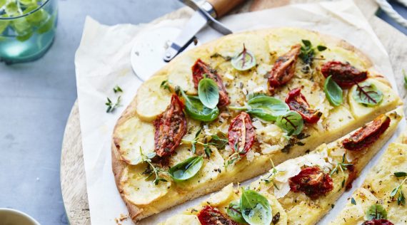 Pizza Bianca mit getrockneten Tomaten, Kräutern und Kartoffeln von oben fotografiert