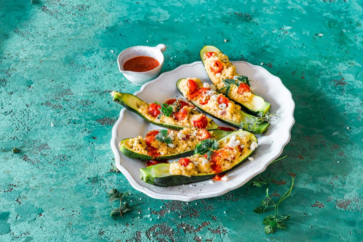 Gefüllte Zucchini mit Couscous auf einem weißen Teller – Foto: Tina Bumann