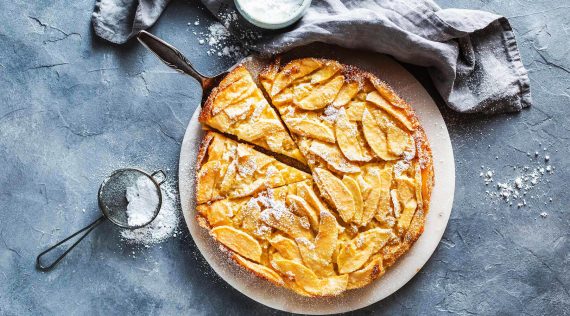 Toskanischer Apfelkuchen von oben fotografiert auf blau-grauem Untergrund– Foto: Anna Gieseler