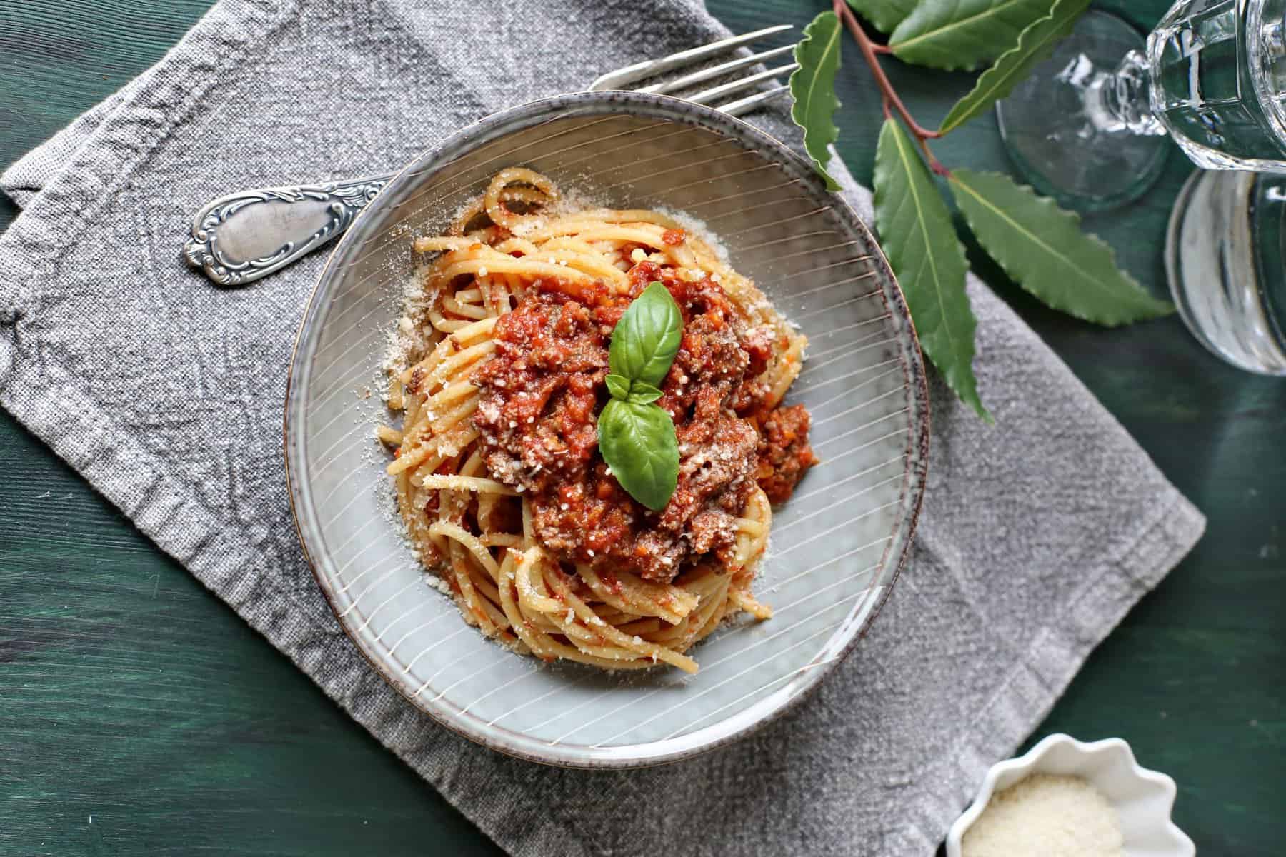 Spaghetti Bolognese mit einem Blatt Basilikum von oben fotografiert – Foto: Alexandra Panella