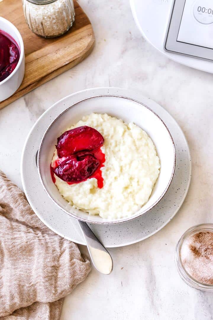 Schale mit Milchreis von oben fotografiert, daneben ein Holzbrett und der Thermomix®