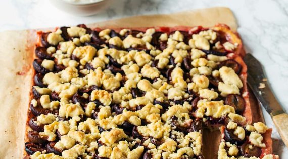 Pflaumenkuchen mit Quark-Öl-Teig auf hellem Untergrund, angeschnitten – Foto: Anna Gieseler