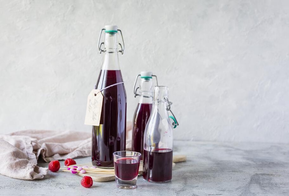 Zwei Flaschen mit rotem Likör, Heiße-Liebe-Likör – Foto: Anna Gieseler