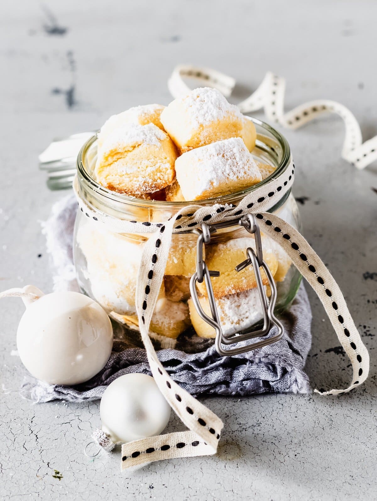 Helle Plätzchen mit Puderzucker in einem offenen Glas – Foto: Désirée Peikert