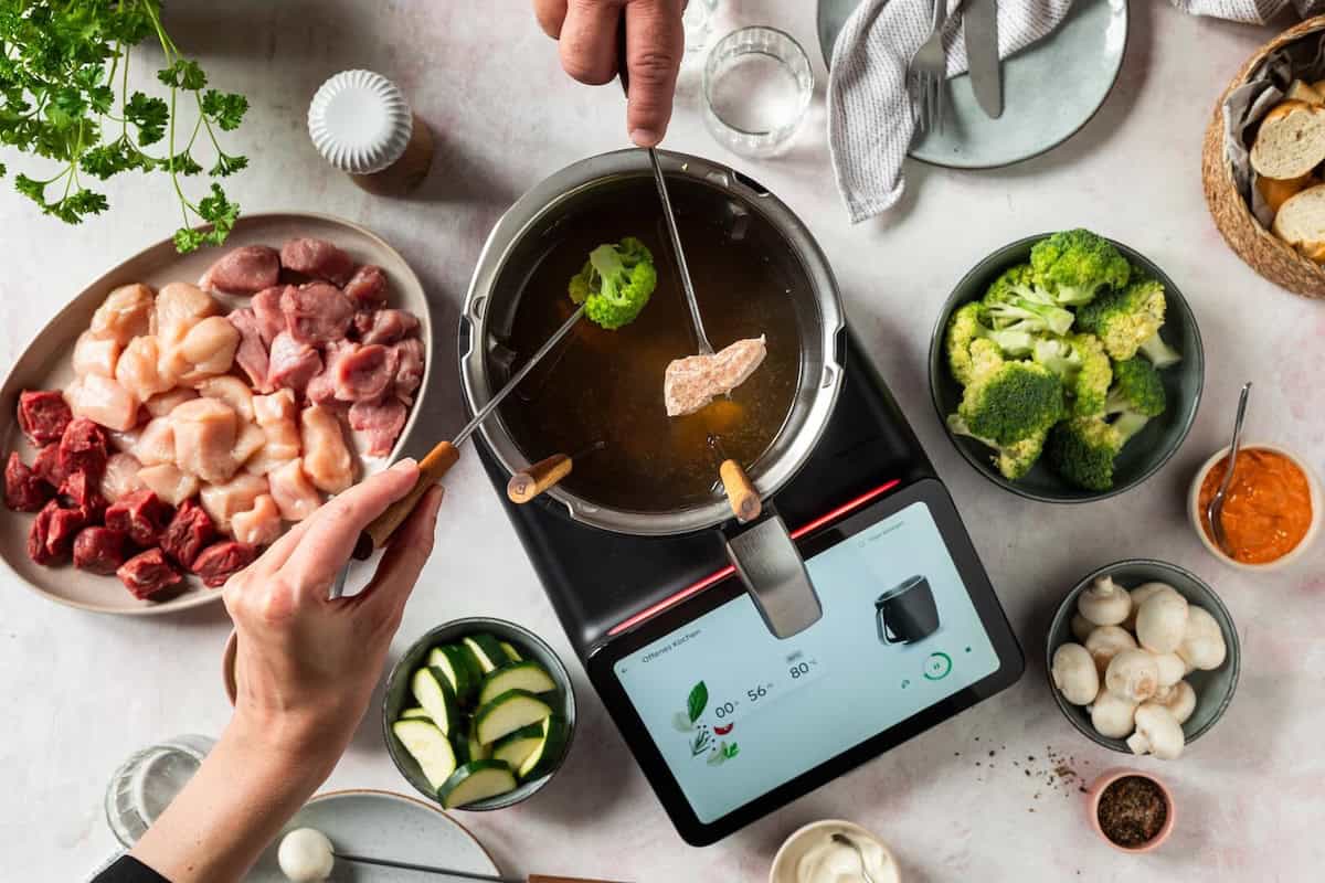 Der Thermomix® TM7 von oben fotografiert mit Fondue-Stäbchen, Fleisch, Brokkoli – Foto: Anna Gieseler