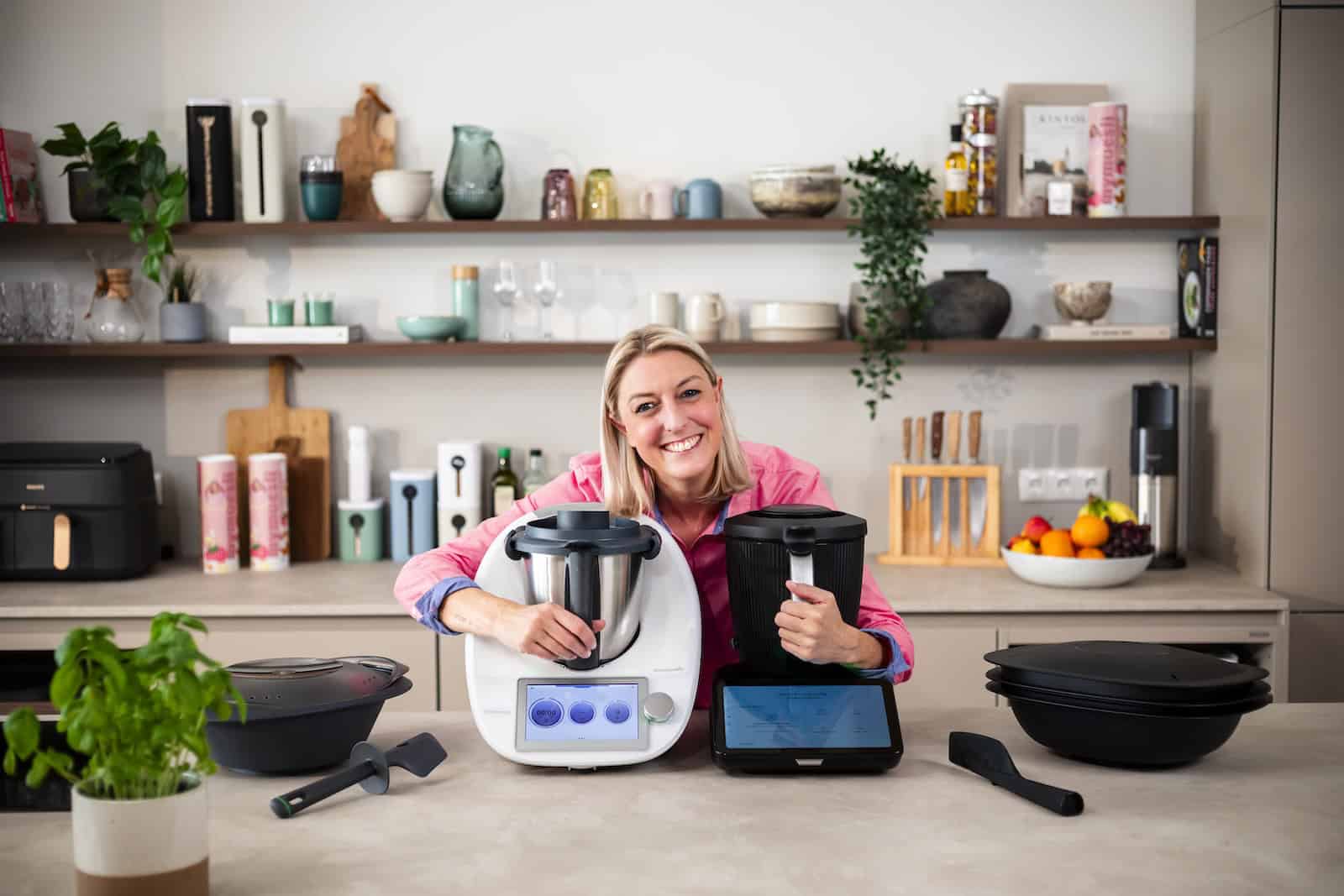 Blonde Frau umarmt den Thermomix® TM6 und TM7