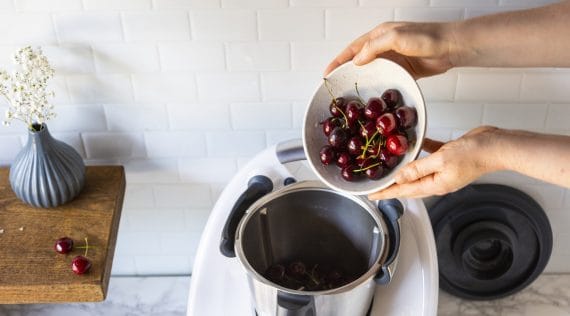 Jemand gibt Kirschen in den Thermomix®