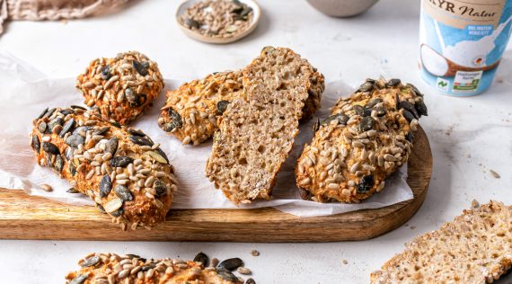 Mehrere Körnerbrötchen auf einem Holzbrett